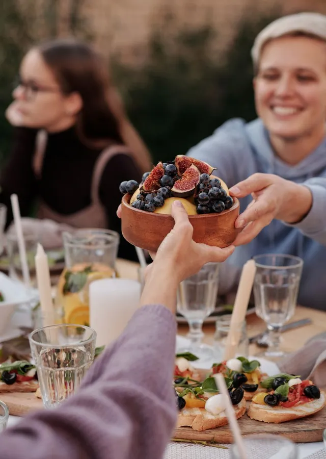 Friends sharing dinner outdoors on a summer evening