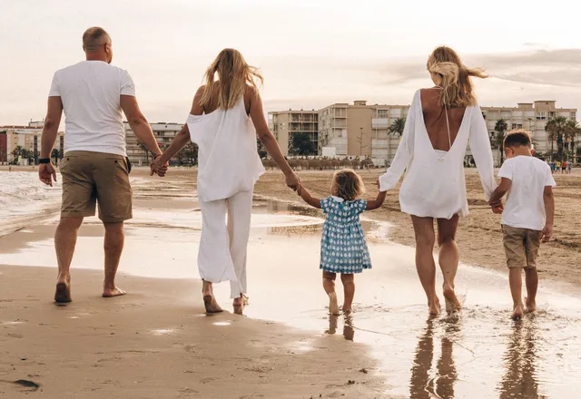 A family walking along the beach at golden hour