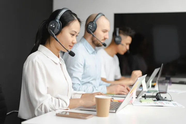 Guest support team answering messages with headsets