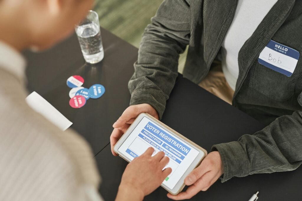 A person registers to vote using a tablet at a modern voting station.